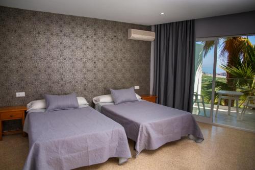 萨各夫雷纳Hotel Salambina的酒店客房设有两张床和一个阳台。