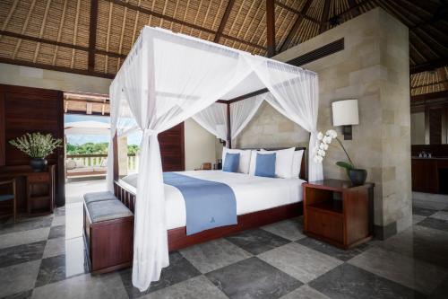 努沙杜瓦REVĪVŌ Wellness Resort Nusa Dua Bali的一间卧室配有一张带天蓬的床