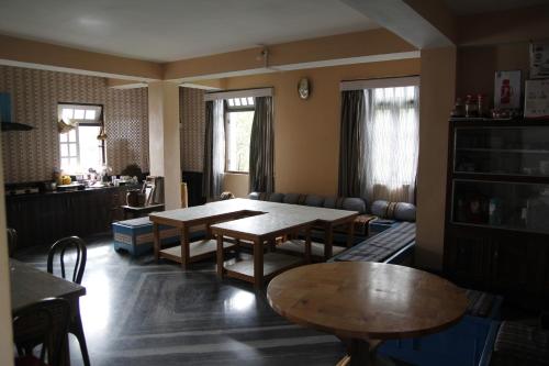 拉瓦格拉Vamoose Sherpa Homestay的客厅配有桌子和沙发