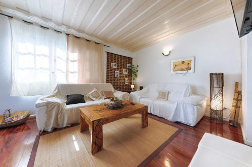 勒唐蓬Villa Ti caz do miel avec piscine et bassin de détente à remous au Tampon pour 8 personnes的客厅配有白色的沙发和桌子