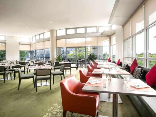 悉尼宜必思悉尼奥林匹克公园酒店的餐厅设有桌椅和窗户。