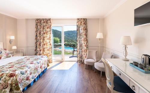 雅弗郎其Hotel BlauMar Llafranc的配有一张床、一张书桌和一扇窗户的酒店客房