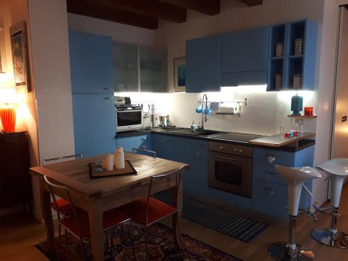 维琴察Mini Contrà San Pietro的厨房配有蓝色橱柜和木桌