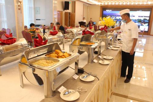 敦煌敦煌福华国际大酒店的厨师站在自助餐线前,提供食物