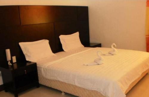 卡利博Asia Novo Boutique Hotel - Kalibo的卧室里床边的两只天鹅