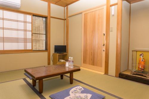 京都Ryokan Hinomoto Kyoto Kawaramachi的客厅配有桌子和电视