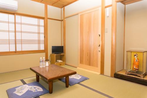 京都Ryokan Hinomoto Kyoto Kawaramachi的客厅配有桌子和电视