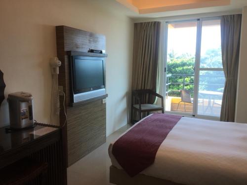 垦丁大街海韵渡假旅店的配有一张床和一台平面电视的酒店客房