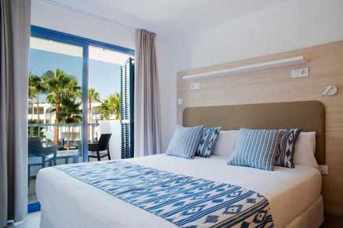 克罗姆港皮埃尔马略卡赛西利亚公寓酒店的一间带大床的卧室和一个阳台
