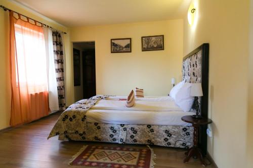 锡吉什瓦拉特兰西瓦尼亚酒店的一间卧室设有一张大床和一个窗户。