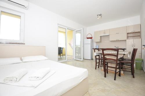斯塔拉诺瓦利亚Apartmani Vrtlici Zdenka的卧室配有一张床和一张桌子及椅子