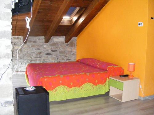 FerriereAlbergo diffuso Casa delle Favole的一间卧室配有一张红色和黄色的床罩