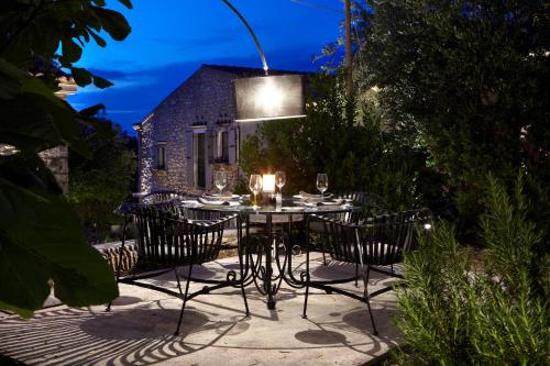 拉卡Torri E Merli Boutique Hotel的晚上在庭院里摆放着桌椅