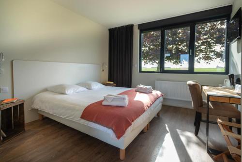 Buigny-Saint-Macloul'AERODROME DE LA BAIE DE SOMME的一间卧室配有一张床,上面有两条毛巾