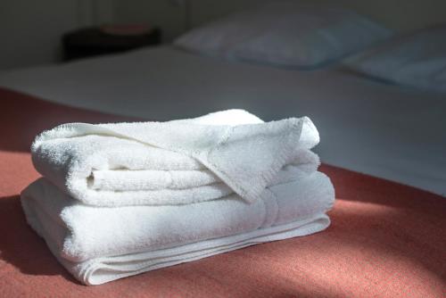 Buigny-Saint-Macloul'AERODROME DE LA BAIE DE SOMME的床上一堆白色毛巾