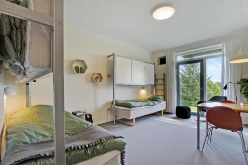 科灵科灵大宿舍酒店的一间卧室配有一张双层床、一张桌子和一张书桌。