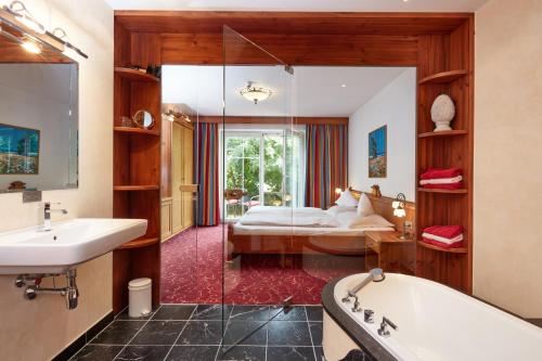 布利克森塔勒胡贝图斯酒店的带浴缸的浴室和1间带1张床的卧室