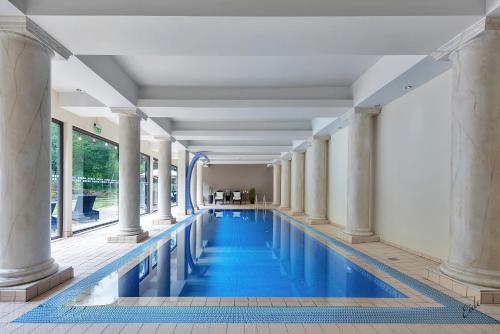 努尔菲尤尔埃德Nordfjord Hotell的一座拥有柱子和蓝色海水的游泳池