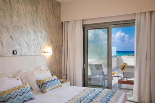 普拉基亚斯Belvedere Luxury Apartments & Spa的一间卧室设有一张床,享有海景