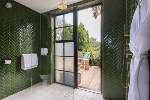 法尔茅斯商旅庄园Spa酒店的浴室设有绿色的墙壁和滑动玻璃门