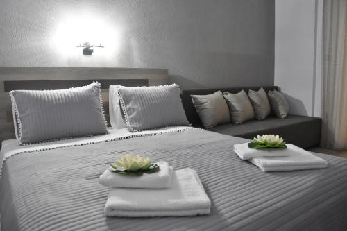 斯塔夫罗斯Dream Studios的一张白色的大床,带毛巾和鲜花