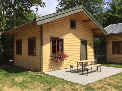 维灵厄韦夫Hollands Oostenrijks huisje的一个带野餐桌和长凳的小房子