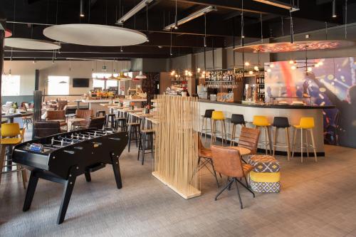 富恩拉夫拉达宜必思马德里丰拉夫拉达酒店的餐厅设有酒吧,配有桌椅