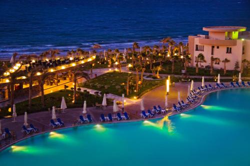 艾因苏赫纳Grand Ocean El Sokhna的享有夜间带游泳池的度假村景色