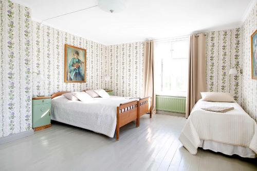 纳坦利Tammiston Bed&Breakfast的一间卧室设有两张床,墙上挂着一幅画
