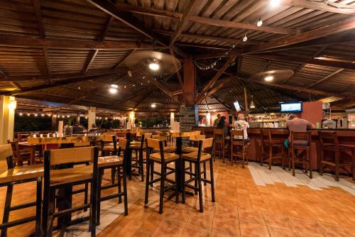 格兰德海滩瑞普杰克酒店的一间带木桌椅的餐厅和一间酒吧