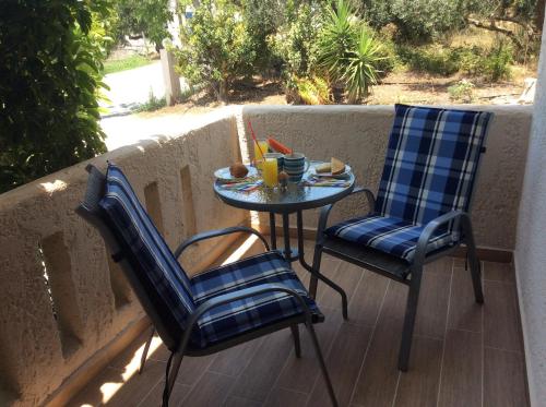 普拉基亚斯艾琳娜旅馆的阳台配有两把椅子和一张小桌子
