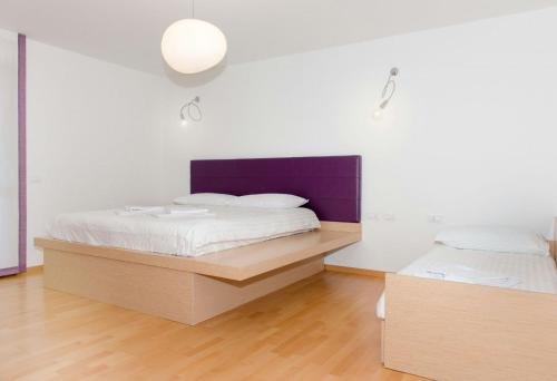 Forni di SottoHotel Pramaggiore的一间卧室设有两张床和紫色床头板