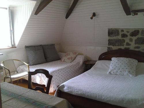 TournemireAuberge Hôtel de Tournemire - Cantal的小房间设有两张床和椅子