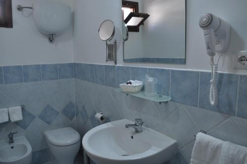 特罗佩阿Il Palombaro Rooms的一间带水槽、卫生间和镜子的浴室
