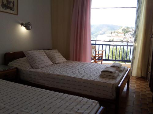 加拉塔斯Bissias Guest House的一间卧室设有两张床,窗户设有阳台