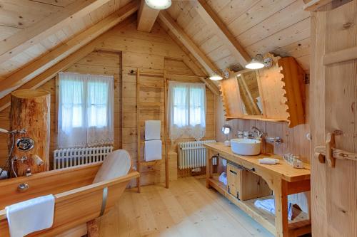 帕特加森Almdorf Seinerzeit的小木屋内的浴室设有水槽和浴缸。