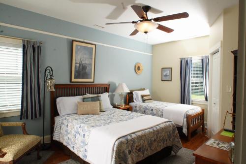 海波因特Seven Oaks Inn Bed and Breakfast的一间卧室配有两张床和吊扇