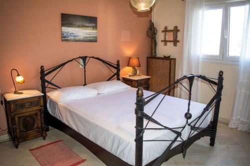 阿凯松Villa marina " G "的一间卧室配有一张黑色框架床和白色床单。