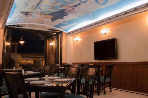 佩雷拉卡斯蒂利亚里奥酒店的用餐室配有桌椅和平面电视。