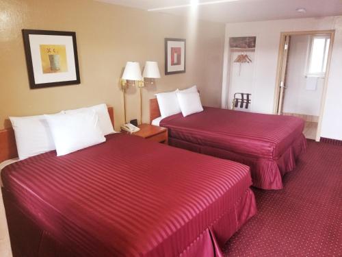 威廉姆斯威廉斯大峡谷入口美国贝斯特唯优酒店的两张位于酒店客房的床铺,配有红色床单