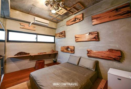 小琉球岛品轩旅宿的一间卧室配有一张床和一堵木墙