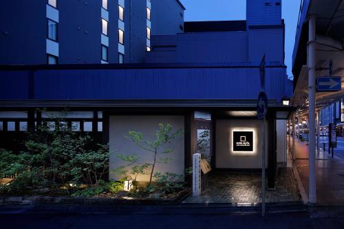 京都京都河原町三条瑞索酒店的一面有一棵树画的建筑物