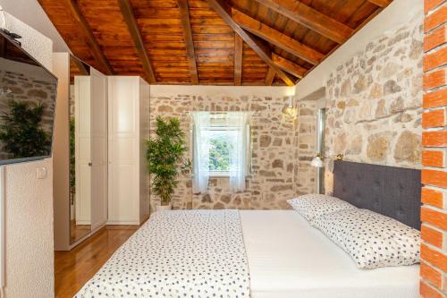 古维达里Villa Klacina的一间卧室设有一张床和石墙
