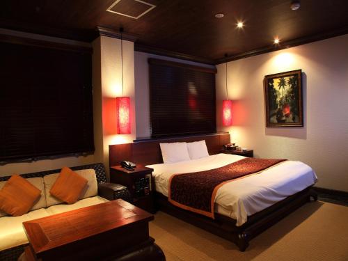 京都Hotel Cuna Kyoto Love Hotel的酒店客房,设有两张床和一张沙发