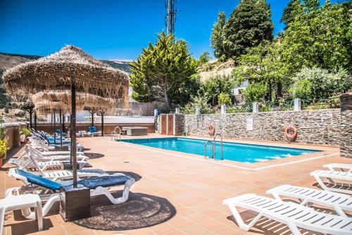 卡皮雷拉利亚诺斯庄园酒店的一个带躺椅的游泳池,一个度假村