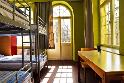 柏林阿姆斯特尔酒店的客房设有双层床、桌子和书桌。