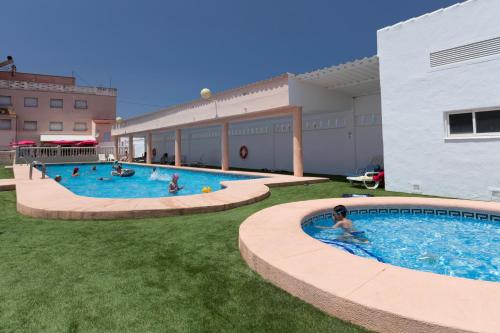 德尼亚洛拉诺斯露营&平房酒店的一群人,在一座建筑物的游泳池里