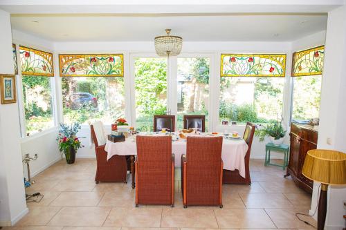 霍恩Bed and Breakfast Hoorn的用餐室配有桌椅和彩色玻璃窗