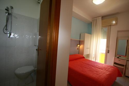 里米尼Hotel Giannella的一间带红色床和卫生间的浴室
