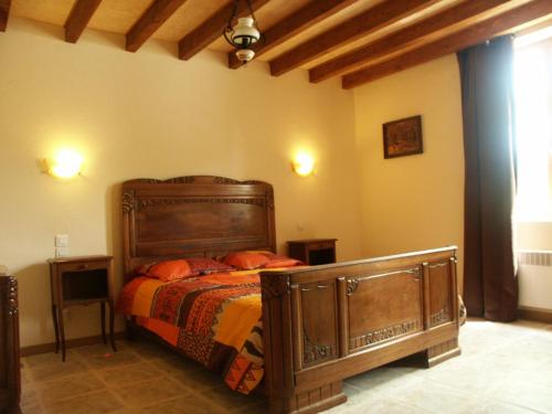 Saint-Dizier-les-Domaines螺旋客房的一间卧室配有带橙色枕头的木床